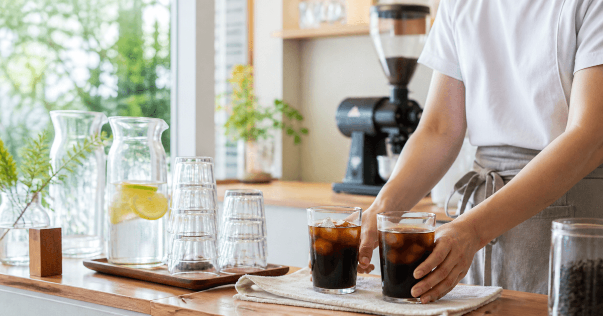 夏の店内でアイスコーヒーを用意する様子